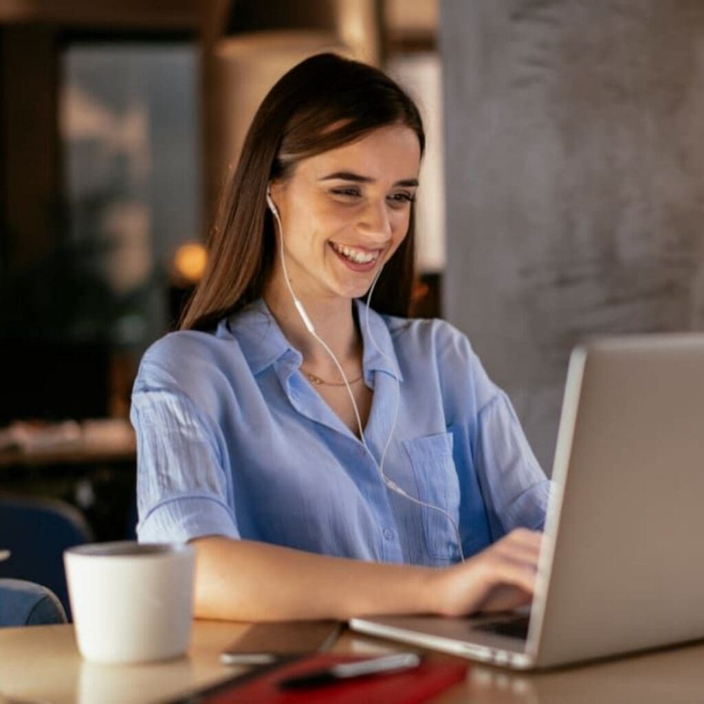 Business woman working on the laptop in the office. Young girl sitting in conference room with laptop. Smiling girl in office space working.